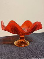 Persimmon red Viking Glass six petal dish side view on pedestal base.