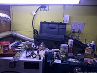 View of painting supplies, tools, locks on surface with countertop, showing paint cans, toolbox, brushes, locks and other tools.