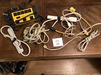 Multiple power bars and assorted cords laid on wooden surface