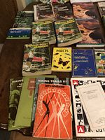 Collection of vintage Scout and outdoor-themed books arranged on table, featuring Canadian Scout Handbooks, insect guide, games, hiking manuals.