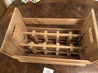 Top angled view of the wooden wine bottle carry case showing internal slots for bottles.