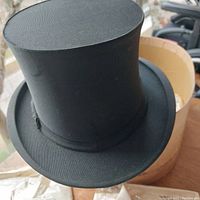 Black silk top hat with high crown and round brim in original box.