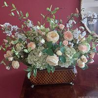 Front view of the full artificial flower arrangement in the planter showing the mix of roses, hydrangea, and greenery.