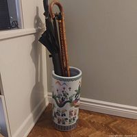 Overview of umbrella stand with umbrellas and canes inside