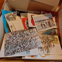 Box filled with various Christmas cards showing a glimpse of different designs inside.