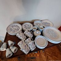 Wide view of set on table showing saucers, plates, bowls, cups, milk jugs, sugar bowl and bowls.