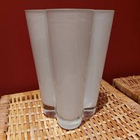 Full side profile showing the vase's smooth opaque milk glass with a curvilinear silhouette.