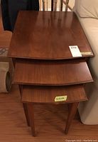 Top view of three stacked wood nesting tables showing the progressively smaller tops.