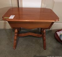 Front view of Roxton wood end table showing smooth polished top and single drawer.