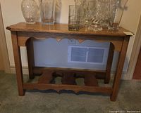Front view of the wooden side table showing scalloped apron and legs with detailed bottom support shelf.