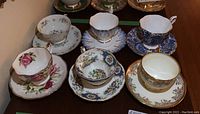 Photo showing all 6 tea cups and their matching saucers arranged on a table, highlighting varied floral patterns and styles.