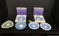 Overview of all six Wedgwood Jasperware pieces with two boxed trays and four small plates