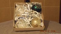 Four vintage glass Christmas ornaments in box, includes green, gold, and two clear glitter designs.
