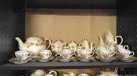 Photo showing full vintage child's tea set including teapot, cups, saucers, sugar bowls and creamer with floral patterns and gold trim