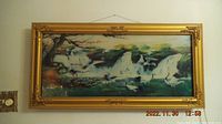 Full view of the lighted hanging picture featuring a blue waterfall and birds with an ornate gold frame