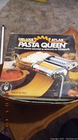 Box of Himark Pasta Queen Deluxe Atlas pasta making machine, made in Italy, showing image and name on front.