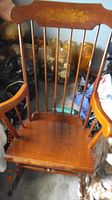 Front view of the rocking chair showing the spindle back and armrests.