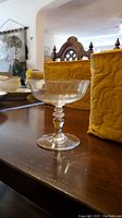 Single coupe glass standing next to yellow quilted case