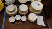 Overview of the assorted plates, bowls, teacups, and saucers stacked on a surface.
