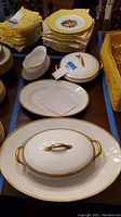Set of stacked plates, covered serving dishes, gravy boat and napkins arranged on table