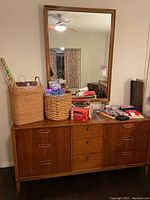 Front view of dresser with mirror and assorted items on top