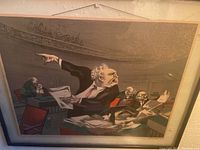 Framed art showing man pointing with observers and crowd above, full view of art and frame.