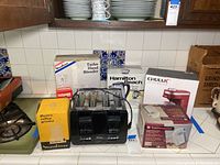Photo of full lot with all appliances on kitchen counter, showing boxes and devices.