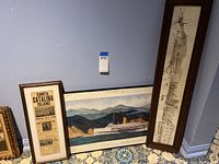 Overview of three framed pieces: the poster, panoramic print/photo, and ship illustration.