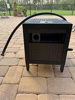 Front view of metal hose reel cabinet with hose forming a loop over the top.