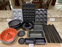 Full overview of bakeware set including muffin pans, cake tins, loaf pans, and baguette pan.