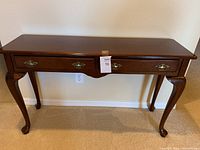 Front view of console table showing two drawers and brass hardware.