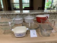 Top view of 16-piece bakeware and serveware on a countertop showing an assortment of glass and ceramic dishes, measuring cups, and containers.