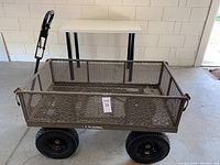 Front view of Gorilla utility cart showing metal mesh sides and the large pneumatic tires on all four corners.