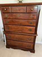 Front view of the highboy showing all 5 drawers and carved detail on the top center drawer.