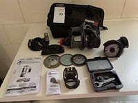 Full overview of Bosch RotoZip rotary cutter with all included accessories and carry bag laid out on a white surface.