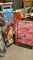 Four art pieces displayed together: two prints and two abstract paintings