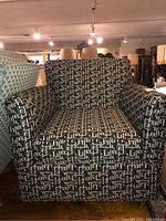 Front view of the upholstered club chair showing geometric pattern upholstery in black, white, and gray.