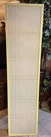 Full view of one panel of the folding screen showing white wood frame and intact paper panel with grid lines