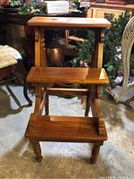 Front view of wooden 2-step stool with polished finish and carved legs.