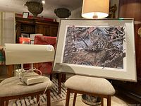 Photo showing SAD sunlight lamp on chair next to framed snow leopard lithograph on second chair