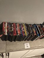 Wide view of a long row of DVD cases arranged in a single line showing mostly spine titles.
