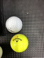 Close-up photo of two Callaway golf balls, one white numbered 3 and one yellow numbered 3