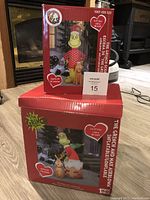 Full packaging box images showing The Grinch inflatable figures with Max and product details.
