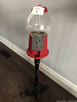 Full view of the gumball machine and stand showing height and design.