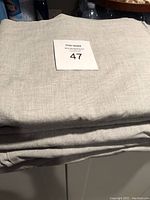 Folded grey curtain fabric showing color and texture.