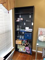 Full front view of the IKEA Billy bookcase filled with various items, showing overall condition and shelving arrangement.