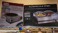 Photo of two boxed kitchen appliances: Ovente electric buffet server and Parini electric ceramic cooktop.