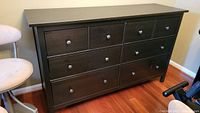 Front view of the Ikea chest of drawers showing the 8 drawers with round black knobs.