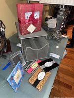 Lot overview showing photo albums, metal desk organizer, photo clutches, and picture frames on table.