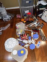 Overview of lot with paper towel holders, Tupperware containers, Pampered Chef tortilla warmer, utensils, knives and scoops.